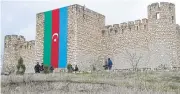  ?? AFP ?? People walk in front of Shahbulag castle outside Aghdam during an Azerbaijan government tour of ‘liberated lands’ on March 12.