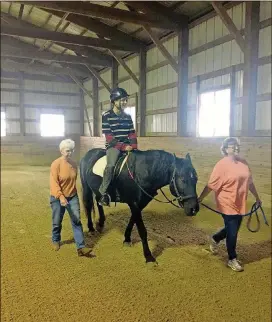  ?? CATHY JANEK / CHICAGO TRIBUNE ?? Volunteers Jan Lauwers and Liz Klemenswic­z with Giant Steps help rider Waqas Kahn during a program at Rich Harvest Farms near Sugar Grove, Ill.