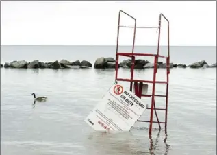  ?? NATHAN DENETTE, THE CANADIAN PRESS ?? Flooded beaches are shown as the Toronto Islands are threatened by rising water levels in May. The waterlogge­d Islands will finally reopen to the public on Monday.