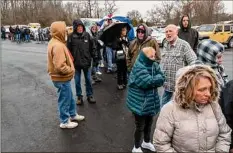  ?? Michael Swensen / Getty Images ?? People wait in line Friday at the Norfolk Southern Assistance Center to collect a $1,000 check to cover expenses while they were evacuated following a train derailment prompting health concerns in East Palenstine, Ohio.