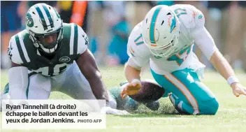  ?? PHOTO AFP ?? Ryan Tannehill (à droite) échappe le ballon devant les yeux de Jordan Jenkins.