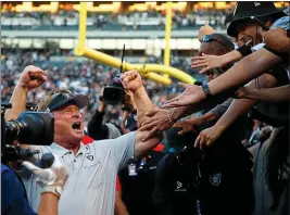  ?? ARIC CRABB — BAY AREA NEWS GROUP ?? Raiders head coach Jon Gruden, left, celebrates with fans after their 17-10 win over the Cincinnati Bengals on Sunday in Oakland.