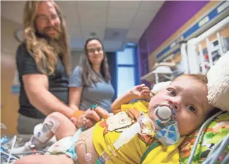  ?? TOM TINGLE, THE ARIZONA REPUBLIC ?? Elias and Samantha Bailey visit their 19-month-old son, Henry, at Phoenix Children’s Hospital last week. Henry has a failing heart and needs a transplant and a lifetime of medical care.