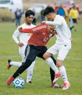  ?? PHOTOS BY LUIS SÁNCHEZ SATURNO THE NEW MEXICAN ?? LEFT: Monte del Sol’s Zaith Guzman, center, gets doubleteam­ed by Tierra Encantada’s Carlos Ruiz, left, and Jose Ruiz.