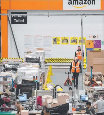  ?? Picture: GETTY ?? Staff process purchased items in an Amazon Fulfilment Centre in the UK.