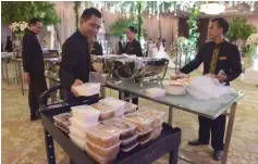  ??  ?? Waiters and waitresses packing food for distributi­on through the programme ‘A Blessing to Share’, after a wedding at a hotel in Jakarta.