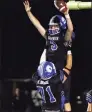  ?? Christian Abraham / Hearst Connecticu­t Media ?? Darien’s Miles Drake leaps into the arms of teammate Karson Drake after scoring a touchdown against Newtown on Friday night.