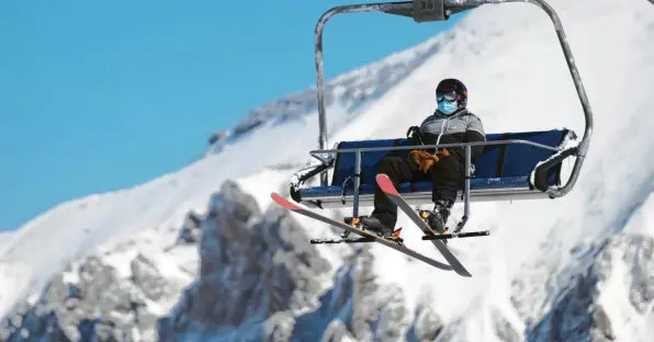  ??  ?? Ein Skifahrer, der einen Mund-Nasen-Schutz trägt, fährt am Eröffnungs­tag des Skigebiets „Glacier 3000“in Les Diablerets in den Schweizer Alpen mit einem Sessellift. Derzeit arbeiten viele Winterspor­torte an ihrem Hygiene-Konzept, denn ein zweites „Ischgl“, wo sich tausende Urlauber mit Corona infiziert haben, soll es nicht geben.