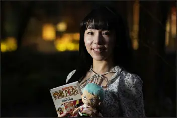  ?? HIRO KOMAE — THE ASSOCIATED PRESS ?? Nina Oiki, a gender and politics researcher at Tokyo’s Waseda University, poses for a photo with some of her favorite “One Piece” anime character goods in Tokyo on Sunday. Oiki has been a “One Piece” fan since she was in elementary school.