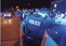  ?? HENRY TAYLOR/THE LEAF-CHRONICLE ?? A Memphis police officer leans against a squad car while the line of protesters passes a corner in downtown in Memphis on May 29.