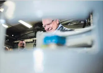  ?? NATHAN DENETTE THE CANADIAN PRESS ?? Ontario PC Leader Doug Ford is framed by a concealed gas container during a campaign stop at Fielding Environmen­tal in Mississaug­a on Wednesday.