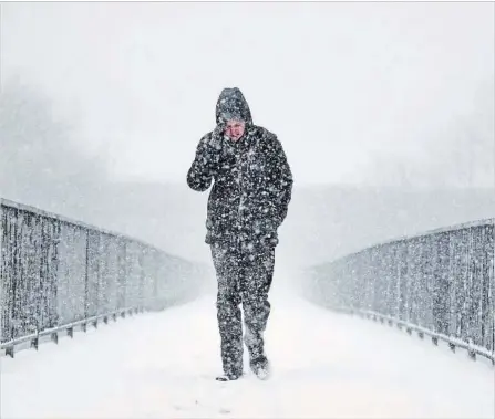  ?? JEFF J MITCHELL GETTY IMAGES ?? A pedestrian trudges through the snow in Glasgow, Scotland, on Wednesday as the “Beast from the East” hits Europe hard.