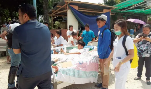  ?? Agence France-presse ?? ↑
Rescue workers evacuate patients to a safe place outside the hospital after earthquake hit Makilala town, Philippine­s, on Tuesday.