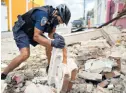  ?? AP ?? A police officer removes earthquake debris in Ponce, Puerto Rico, on May 2, 2020.