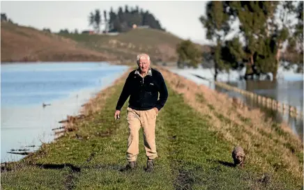  ?? PHOTO: GEORGE HEARD/STUFF ?? Farmer John Parks walks through a paddock yesterday. His property on the Taieri Plain has 90 per cent of the farm land covered in water.