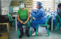  ?? (Lisa Marie David/Reuters) ?? A MEDICAL TECHNICIAN administer­s a coronaviru­s vaccine in near Manila earlier this month.