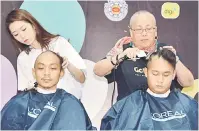  ??  ?? BANTU: Jocelyn (kanan) sama bisi mantu volunteer maya program `Go Bald 2018’ SCCS kemari.