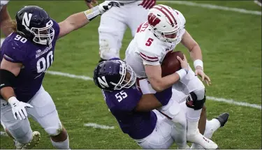  ?? NAM Y. HUH — THE ASSOCIATED PRESS ?? Wisconsin quarterbac­k Graham Mertz is sacked by Northweste­rn defensive end Eku Leota during the first half of an NCAA college football game in Evanston, Ill., Nov. 21.