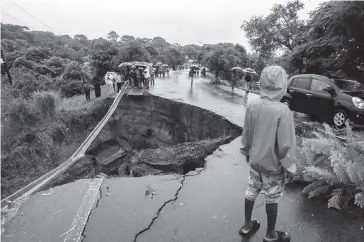  ?? FOTO: AFP ?? Carretera colapsa por las inundacion­es debido a las fuertes lluvias.