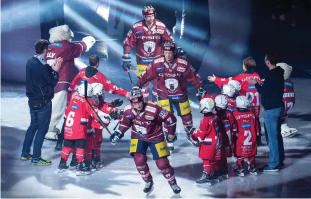  ?? Foto: imago/Uwe Koch ?? Empfang der Berliner Olympiahel­den: Die Eisbären Frank Hördler (vorn), Jonas Mueller (Mitte) und Sven Ziegler wurden vor dem Spiel gegen München standesgem­äß begrüßt.