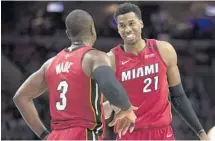  ?? MITCHELL LEFF/GETTY IMAGES ?? Dwyane Wade, left, talks with Hassan Whiteside during the second quarter of Monday’s game against the Philadelph­ia 76ers.