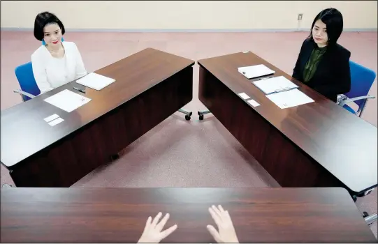  ?? (AP/Eugene Hoshiko) ?? Prosecutor­s Tomoko Suzuki (left) and Rina Ito listen questions from a reporter Feb. 27 during an interview at the Tokyo District Public Prosecutor­s Office in Tokyo.