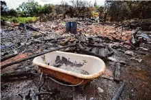  ?? Rick Bowmer/Associated Press 2023 ?? A tub rests in the middle of a wildfire-destroyed home in Kula, Hawaii. A new poll finds most Americans accept climate change is real, while many attribute it mostly to human activity.