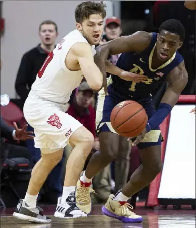  ?? Ben McKeown/Associated Press ?? Xavier Johnson, right, and N.C. State’s Braxton Beverly battle for a loose ball Saturday. Johnson had a game-high six turnovers in the Panthers’ 86-80 defeat.