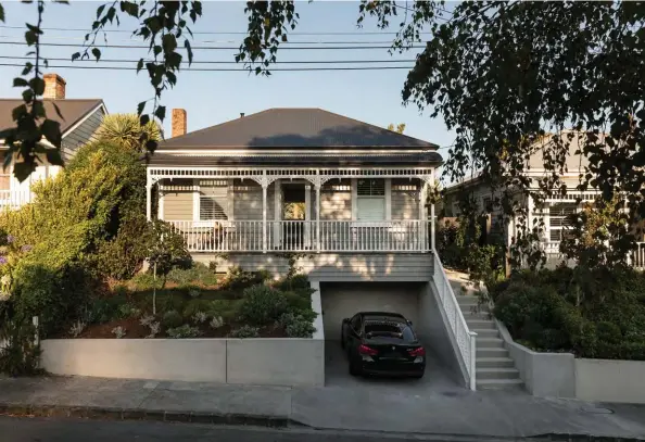  ??  ?? ABOVE The design and elevation of the home’s frontage remains completely unchanged (the only additions to this area being an off-street carpark and concrete staircase); it’s painted in muted grey Resene Stack, with Resene White highlighti­ng the intricate villa detailing. Amber says she and Andrew love the playfulnes­s of this light-dark contrast between front and back. PREVIOUS PAGE Landscape with Figure Reflecting on the Confines of Space by Alan Ibel from Sanderson Contempora­ry catches the light in the living area.