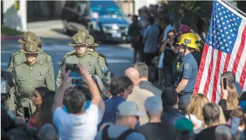  ??  ?? Des policiers ont recueilli les témoignage­s de plusieurs personnes, mercredi soir, à l’extérieur du Borderline Bar &amp; Grill, quelques moments après la tuerie. Sur la photo du bas, un hommage a été rendu au policier Ron Helus, abattu la veille par le tireur. PHOTOS AFP