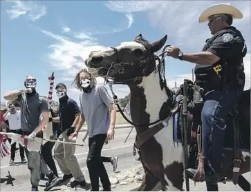  ?? Irfan Khan Los Angeles Times ?? ANTI-SHARIA protesters gather Saturday near the site of the 2015 San Bernardino terror attacks. The rally was sponsored by Act for America, which the Southern Poverty Law Center calls an anti-Muslim hate group.