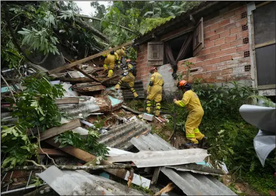  ?? PHOTOS BY ANDRE PENNER — THE ASSOCIATED PRESS ?? Rescue workers search for survivors after flooding triggered deadly landslides near Juquehy beach in Sao Sebastiao, Brazil, on Monday.
