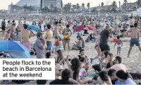  ??  ?? People flock to the beach in Barcelona at the weekend