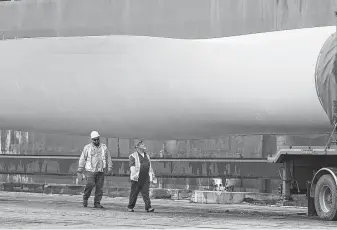  ?? John Davenport / San Antonio Express-News ?? Wind turbine blades are offloaded at the Port of Corpus Christi. The wind industry will see an inflection point in three years when operations and maintenanc­e costs outpace new installati­ons.