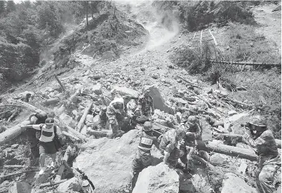  ?? — Gambar Reuters ?? ANGGOTA polis separa tentera membawa seorang mangsa yang cedera selepas gempa bumi melanda daerah Jiuzhaigou, bahagian Ngawa di negeri Sichuan, semalam.