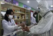  ?? AP PHOTO/JON CHOL JIN ?? An employees of the Medicament Management Office of the Daesong District in Pyongyang provides medicine to a resident as the state increases measures to stop the spread of illness in Pyongyang, North Korea, Monday, May 16, 2022.