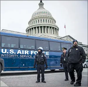  ?? The New York Times/SARAH SILBIGER ?? Police and Air Force personnel stand outside the U.S. Capitol near a bus that was supposed to take House Speaker Nancy Pelosi and other lawmakers to a waiting military plane Thursday for an overseas trip.
