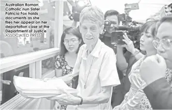  ?? ASSOCIATED PRESS ?? Australian Roman Catholic nun Sister Patricia Fox holds documents as she files her appeal on her deportatio­n case at the Department of Justice.