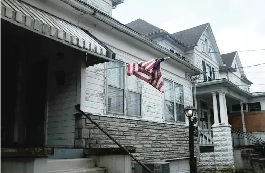  ?? SPENCER PLATT/GETTY IMAGES ?? An American flag hangs outside of a home in Clarksburg, West Virginia, a state that struggles with endemic poverty.