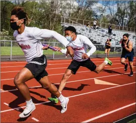  ?? JAMES BEAVER/FOR MEDIANEWS GROUP ?? Hatboro-Horsham junior Cole Jackson hands three baton off to Markel Roberts-Jackson during the boys 4x100 meter relay at the Hatboro-Horsham Track Invitation­al.