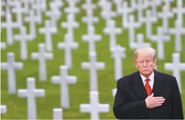  ?? Saul Loeb / AFP / Getty Images ?? President Trump takes part in a ceremony honoring war dead at the Suresness American Cemetery.