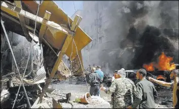  ?? SANA VIA AP ?? Syrians gather around damaged buildings after a bombing Saturday in a suburb of Damascus, Syria. Twin bombings killed 12 people and wounded dozens more.