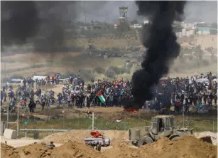  ??  ?? GAZANS MOVE toward the security fence and IDF soldiers last month.