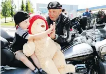  ?? DARREN MAKOWICHUK ?? Lincoln Nitschke, 4, greets Tom Fredericks, ECL Choppers for Charity event founder and organizer, during Saturday’s ride.