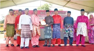  ??  ?? MASARI (empat dari kiri) menerima Anugerah Tokoh Maulidur Rasul disampaika­n Rozman.