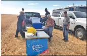  ?? Photo courtesy of Rick Block, Canadian Foodgrains Bank ?? Volunteers enjoy a break during the harvesting of the durum wheat crop at the Stewart Valley project site, Aug. 19.