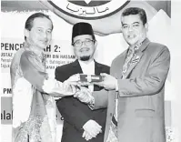  ??  ?? ISU SERIUS: Yusof (kiri) menerima cenderahat­i daripada Ketua Penolong Pengarah Kanan Bahagian Jabatan Kemajuan Islam Malaysia (JAKIM) Mohamad Kori Jusoh (kanan).