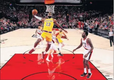  ??  ?? POR LOS AIRES. LeBron James vuela para machacar en su estreno con la camiseta de los Lakers.