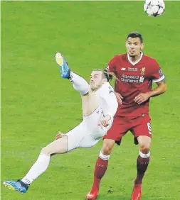  ?? Ap / darko vojinovic ?? Arriba, Gareth Bale patea el balón para convertir un sensaciona­l gol que le dio la ventaja definitiva al Real Madrid para conquistar el título de la Liga de Campeones ante Liverpool. Al lado, los jugadores celebran el triunfo.