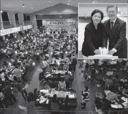  ??  ?? South Korean election officials sort voting papers for ballot counting in the presidenti­al election in Seoul on Tuesday. (inset) South Korean presidenti­al candidate Moon Jae-in of the Democratic Party and his wife Kim Jung-suk prepare to cast their...